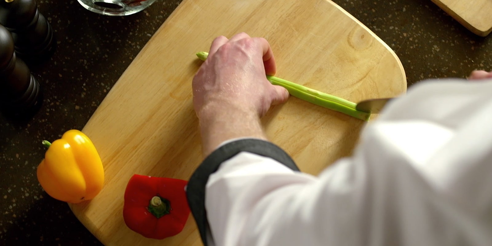 The chef is trimming the ingredients.