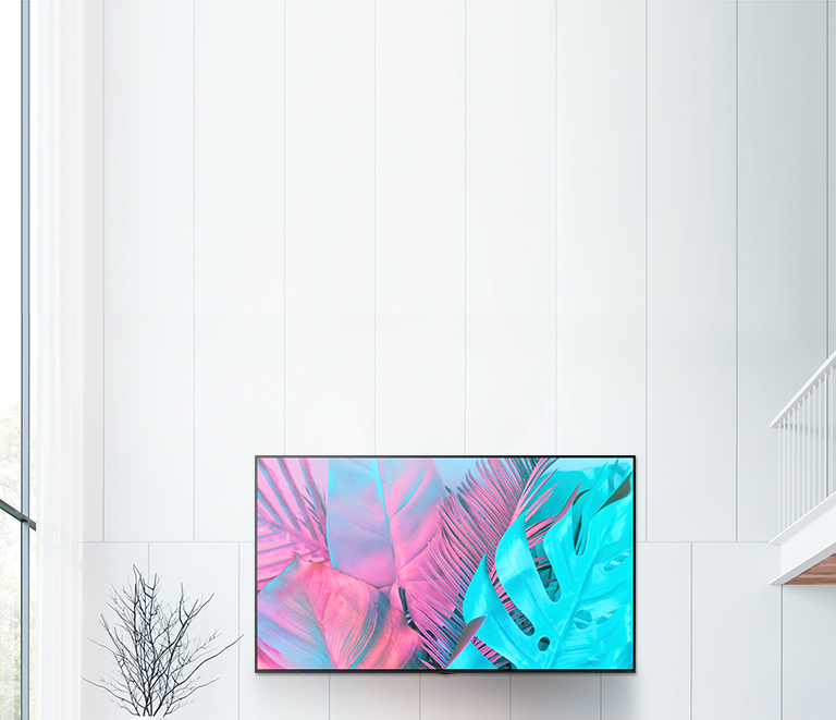 A large flatscreen TV mounted against a white wall. The screen shows large leaves in bright colors.