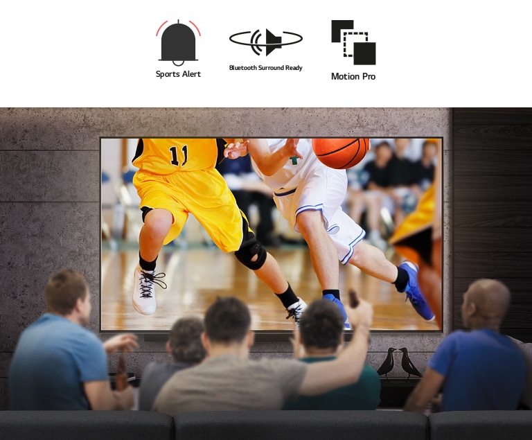 Rear view of a group of men sat in front of a large wall-mounted TV. The screen shows basketball players.