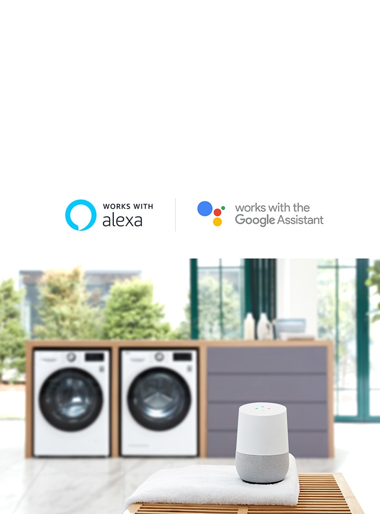 Background of the image is two washing machine front loading washers in a built in folding station slightly blurred with the LG ThinQ sitting on a towel on a table in the foreground.